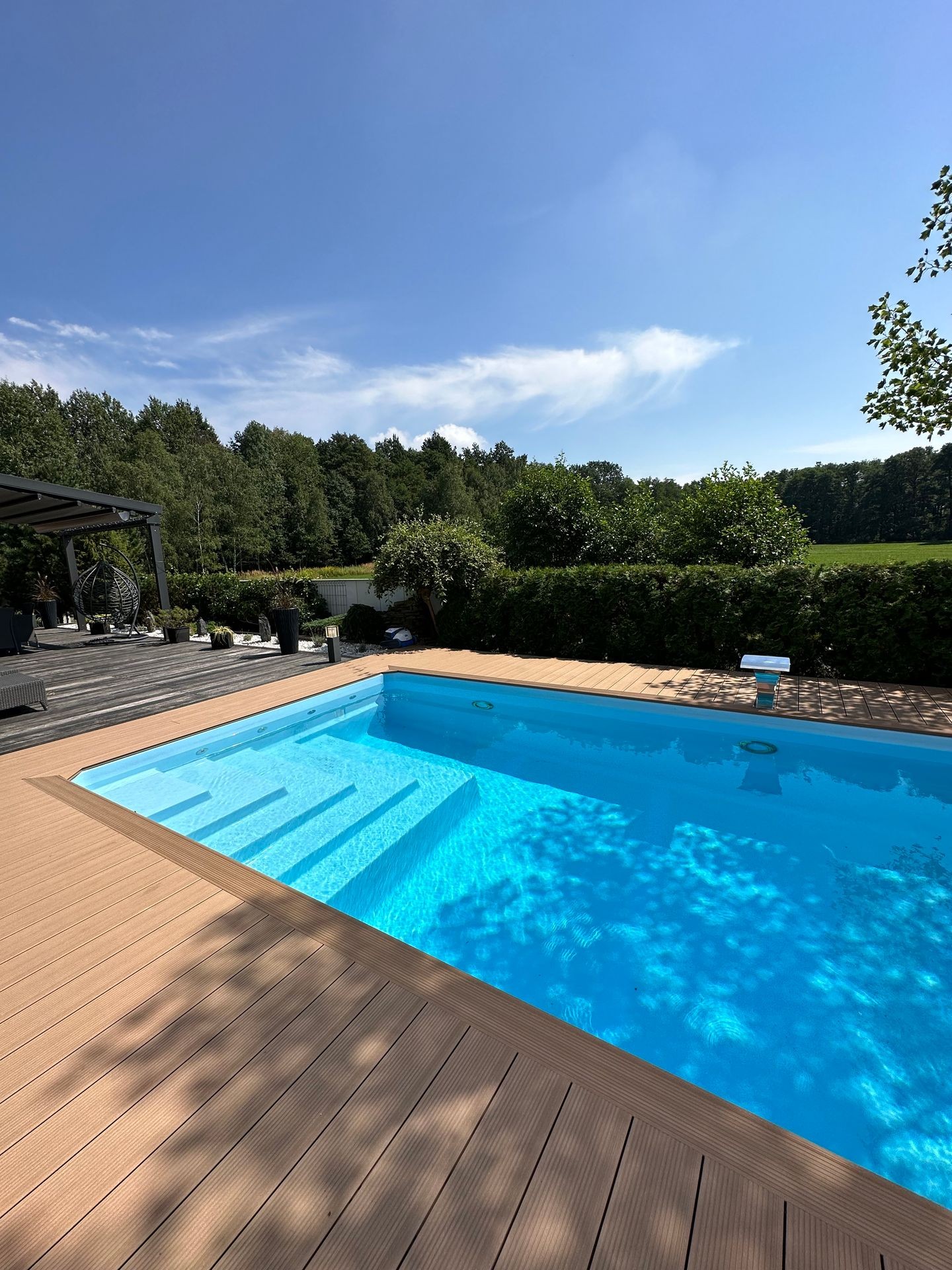 Moderner rechteckiger GFK-Pool Pool4You im Garten mit Holzdeck und Liegestühlen – ideal für Einsteiger
