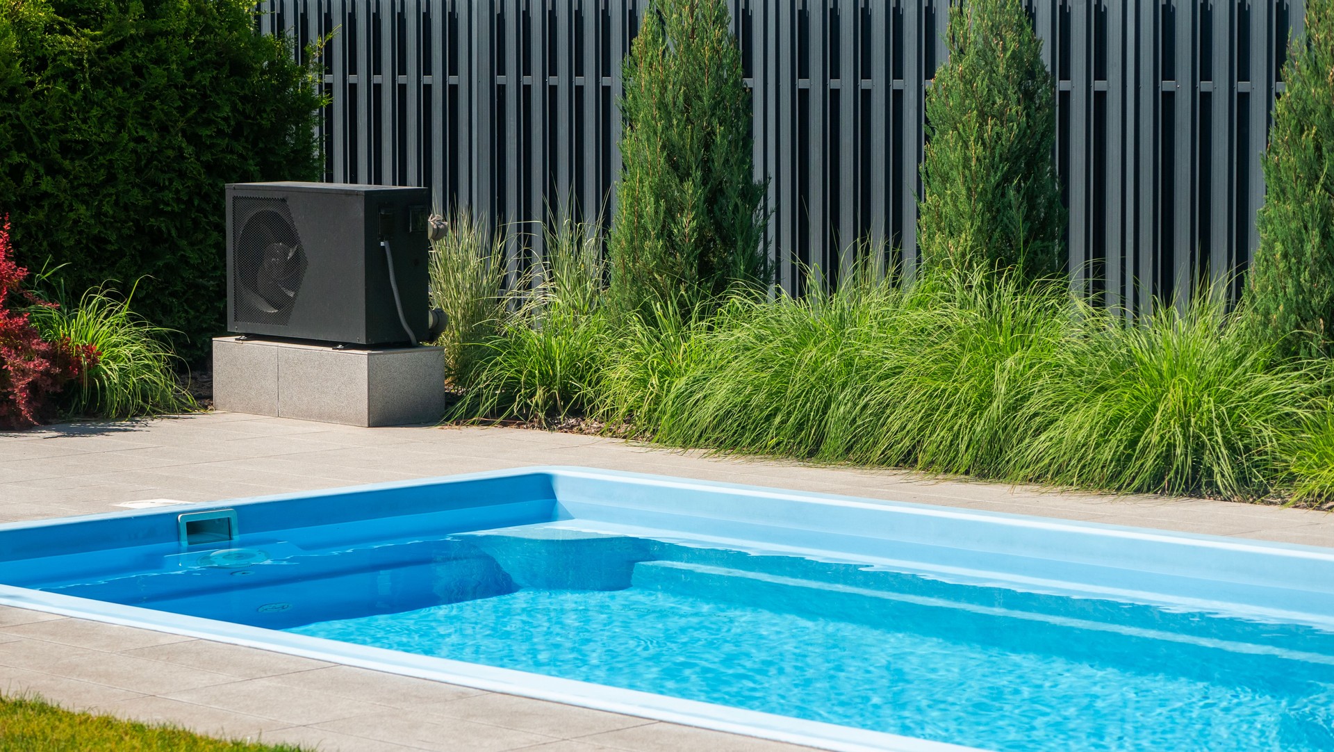 Laminatpool von PoolsFactory in einem modernen Garten mit Sichtschutz und Begrünung.
